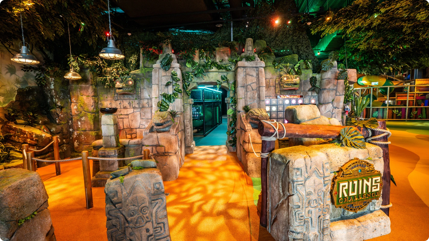 Dimly lit jungle-themed ruins entrance with carved stone pillars and a 'Ruins Challenge' sign, adventurous mood.