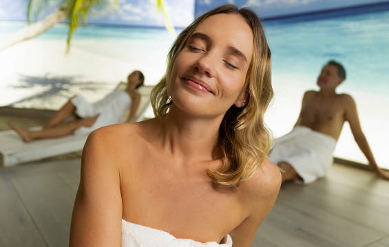 Couple relaxing in pool with cocktails in tropical atmosphere with palm shadows