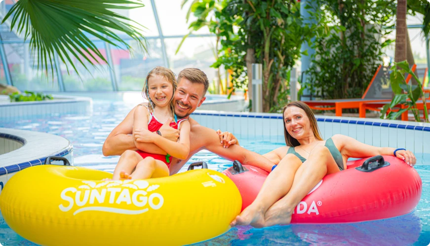 Family on inflatable tubes in the pool, smiling and relaxed