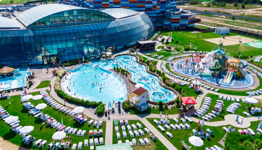 Outdoor section of Suntago, with pools and slides, surrounded by sunbeds and greenery