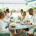 A group of friends dining together in a restaurant overlooking the pool