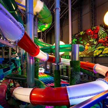 Colorful area with multi-level slides and tropical decoration