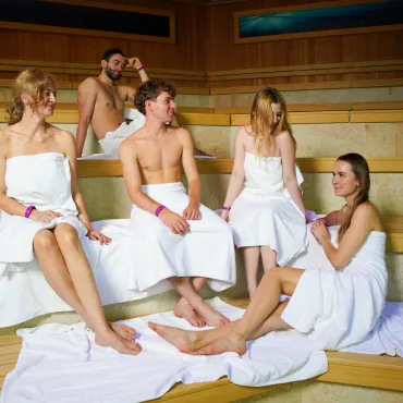 Group of people in towels relaxing in the Saunaria zone