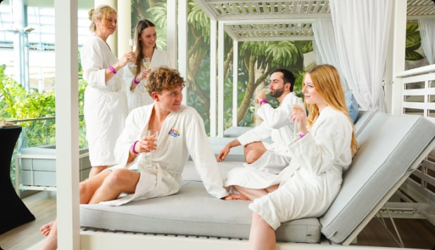 A group of friends toasting on canopy loungers