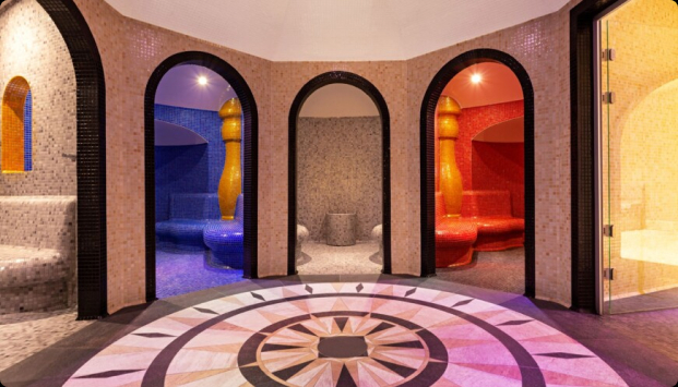 Pokój z kolorowymi ścianami wyłożonymi kafelkami i okrągłą podłogą tworzącą wesołą atmosferę